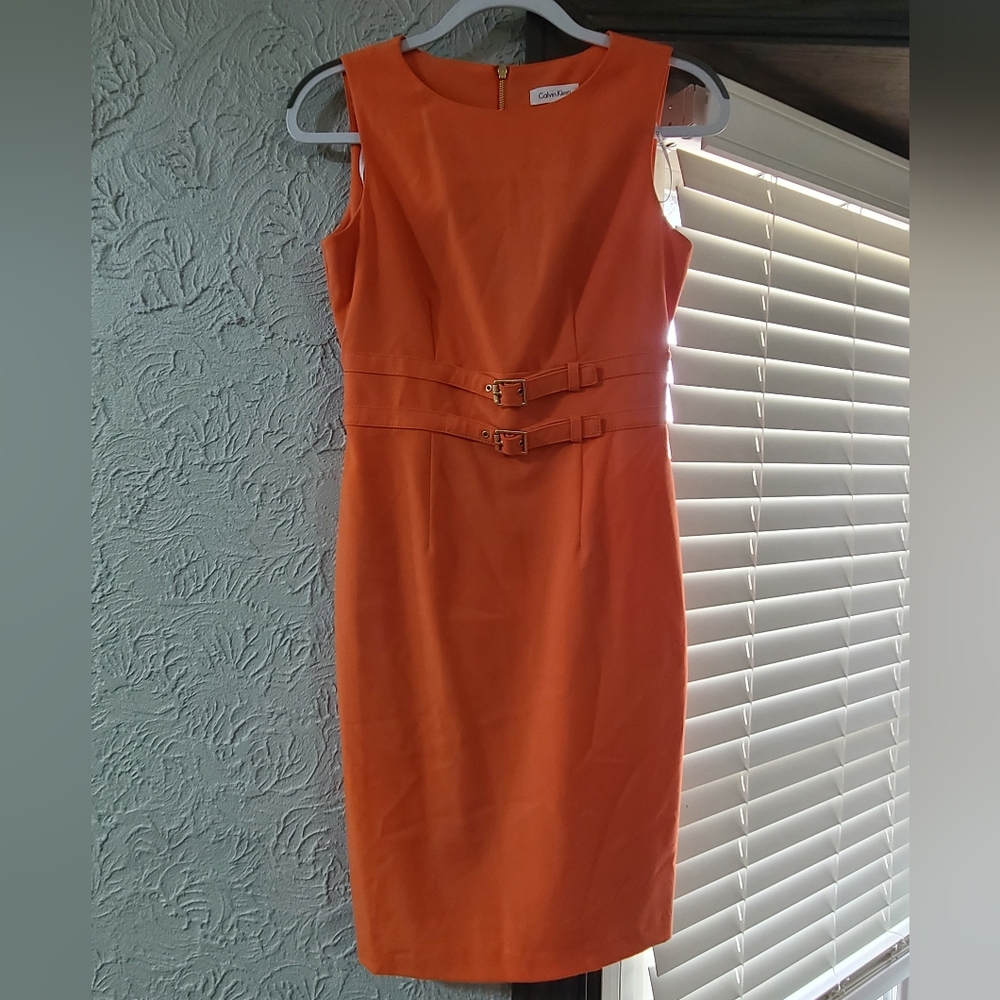 sleeveless orange Calvin Klein sheath dress featuring a decorative double-buckle